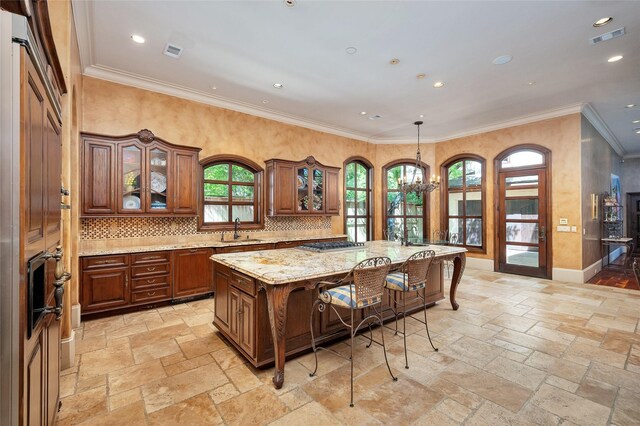 5530 Tilbury Dr, Houston, TX 77056 - kitchen featuring stone tile flooring, a sink, brown cabinetry, and a breakfast bar