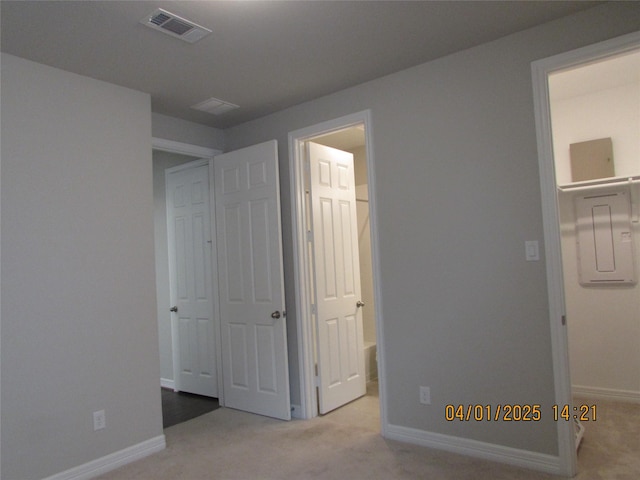 unfurnished bedroom featuring carpet, visible vents, baseboards, and ensuite bathroom