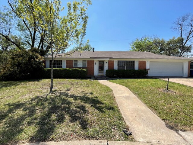 single story home with a front yard, driveway, brick siding, and a garage