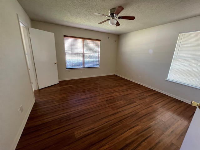 empty room with a textured ceiling, wood finished floors, baseboards, and a ceiling fan