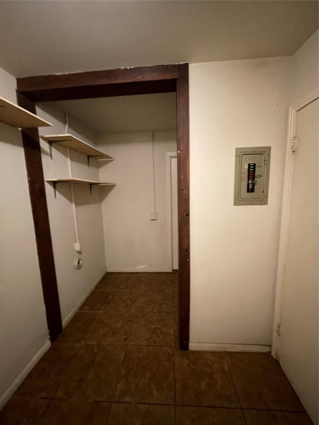 clothes washing area with dark tile patterned floors and electric panel