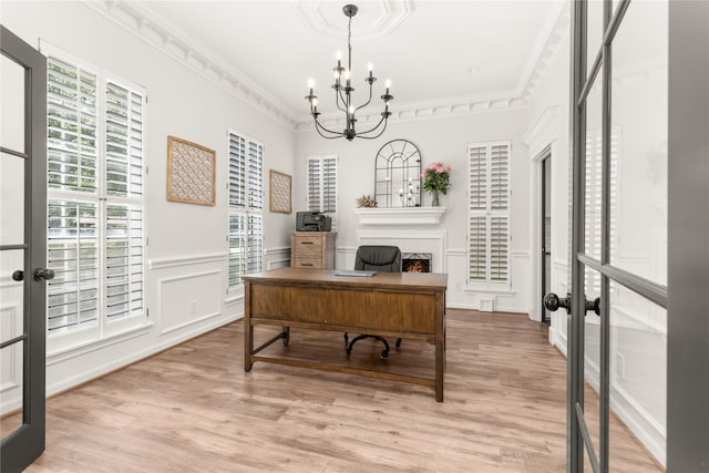 home office featuring a chandelier, french doors, healthy amount of natural light, light wood-style floors, and ornamental molding