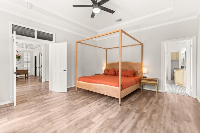 bedroom with light wood finished floors, ornamental molding, and baseboards