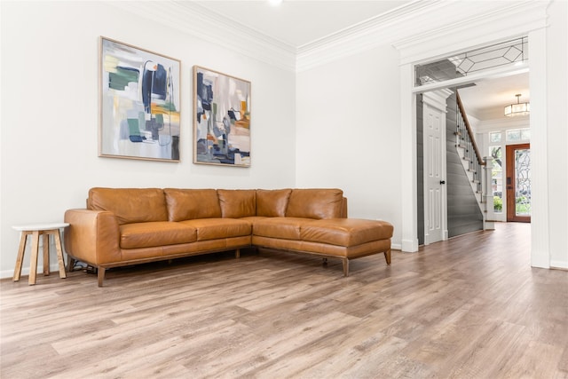 living room with crown molding, wood finished floors, stairs, baseboards, and a chandelier
