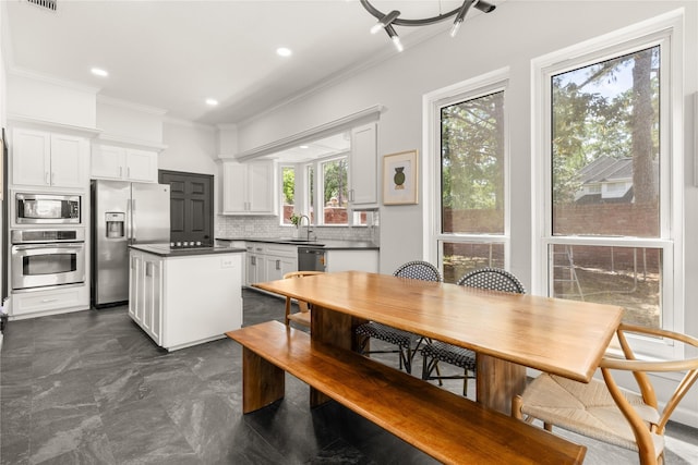 dining space with ornamental molding and recessed lighting