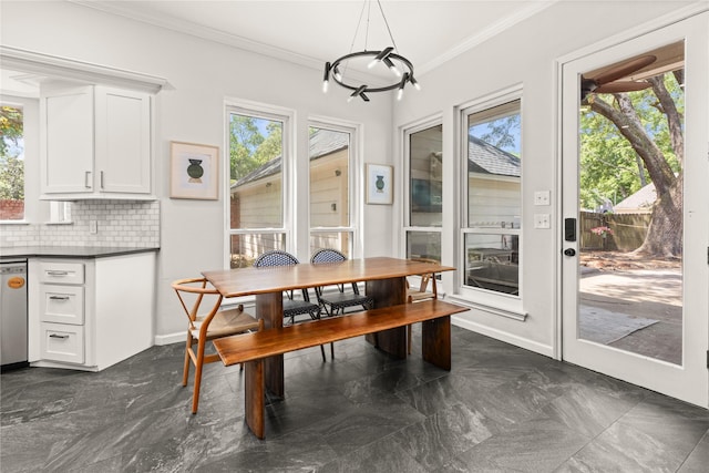 dining space featuring crown molding, a chandelier, and baseboards
