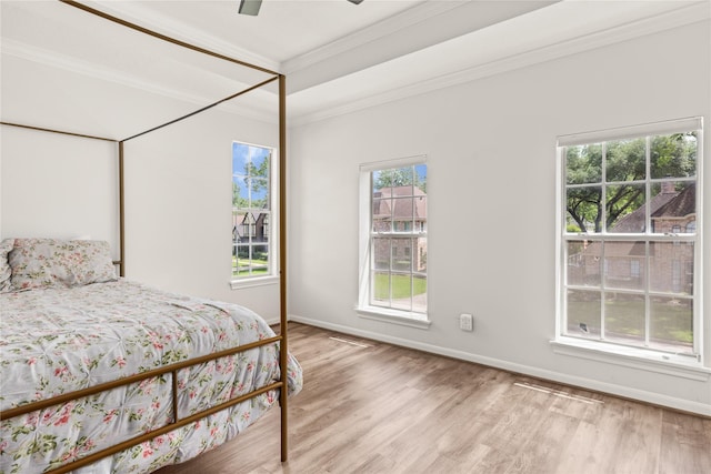 bedroom with wood finished floors, ornamental molding, baseboards, and a ceiling fan