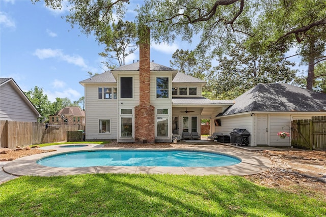 back of house with an outdoor hot tub, ceiling fan, and a patio area