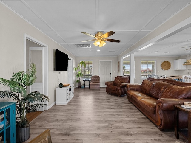 living room featuring light wood-type flooring, ceiling fan, visible vents, and recessed lighting