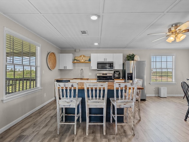dining space featuring light wood-style floors, baseboards, visible vents, and recessed lighting