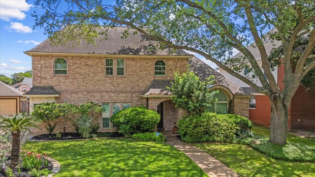 7914 Rio Crystal Dr, Houston, TX 77095 - view of front of home with a front yard, a shingled roof, and brick siding