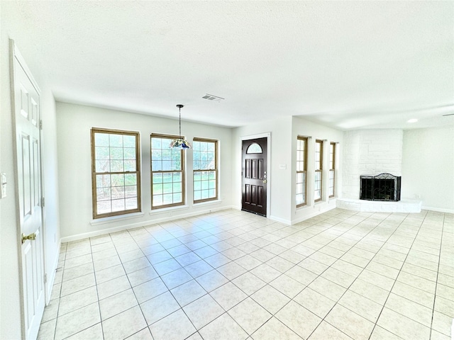 7914 Oakington Dr, Houston, TX 77071 - unfurnished living room featuring light tile patterned flooring, a textured ceiling, a fireplace, and baseboards