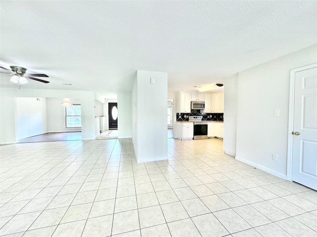 7914 Oakington Dr, Houston, TX 77071 - unfurnished living room with light tile patterned floors, a textured ceiling, baseboards, and a ceiling fan