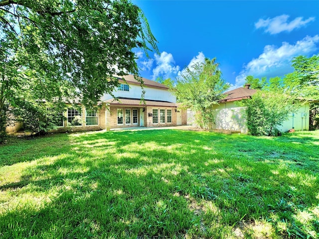 7914 Oakington Dr, Houston, TX 77071 - back of property featuring french doors, a lawn, and brick siding