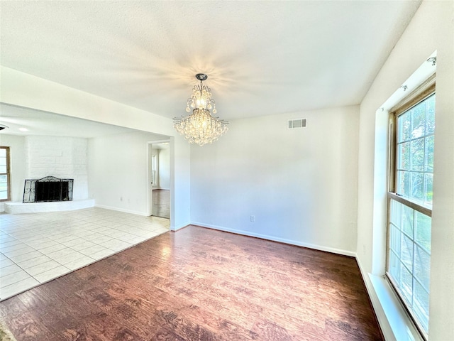 7914 Oakington Dr, Houston, TX 77071 - unfurnished living room with a chandelier, wood finished floors, a fireplace, and baseboards