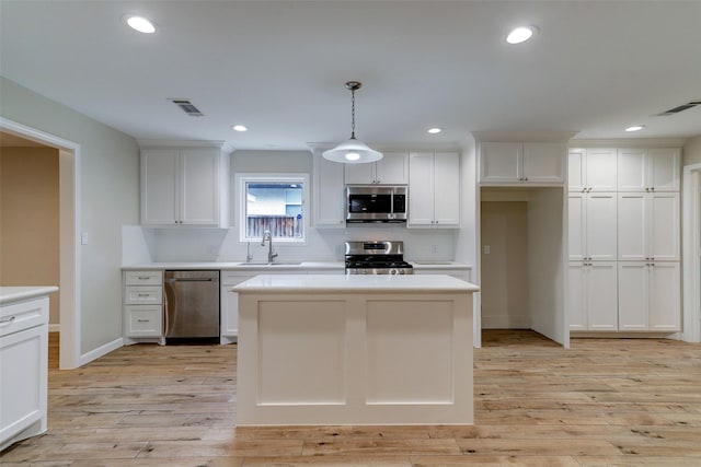 kitchen with white cabinets, appliances with stainless steel finishes, visible vents, and a sink