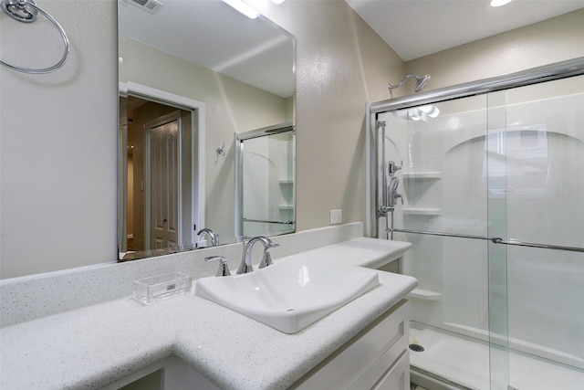 full bath with vanity, visible vents, and a shower stall