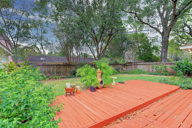 wooden terrace with a fenced backyard