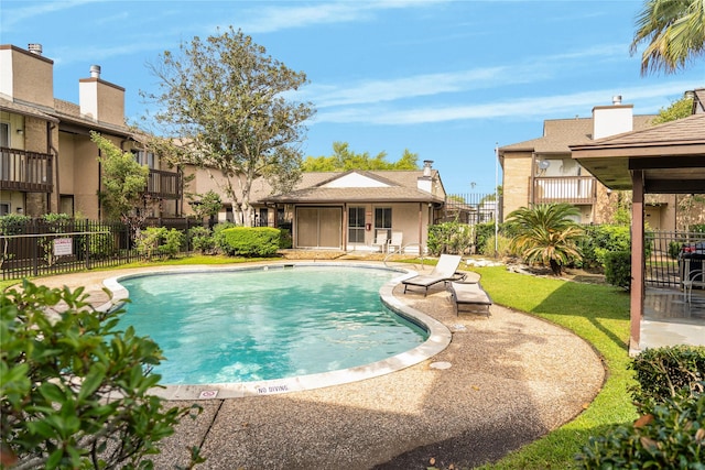 pool with a patio area, fence, and an outdoor structure