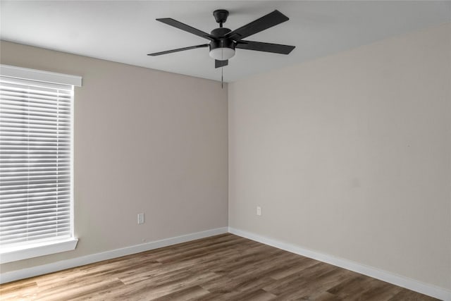 spare room featuring ceiling fan, wood finished floors, and baseboards
