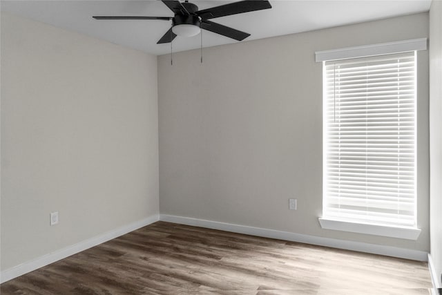 spare room with baseboards, a ceiling fan, and wood finished floors