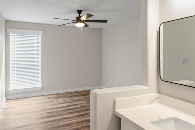bathroom with vanity, baseboards, wood finished floors, and ceiling fan