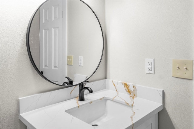bathroom featuring a textured wall and vanity