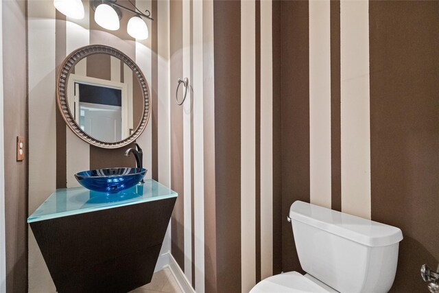 half bath featuring toilet and a sink