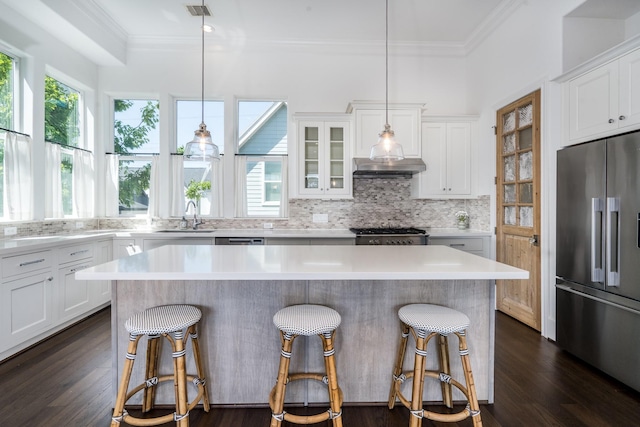 8624 Emnora Ln, Houston, TX 77080 - kitchen featuring high quality fridge, ornamental molding, a breakfast bar, a sink, and backsplash