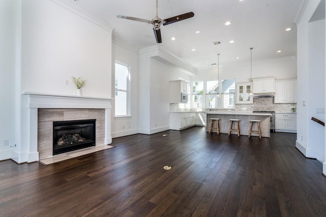 8624 Emnora Ln, Houston, TX 77080 - living area with a ceiling fan, dark wood finished floors, a tile fireplace, ornamental molding, and recessed lighting