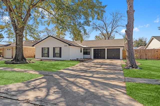 ranch-style home with an attached garage, concrete driveway, a front yard, and fence