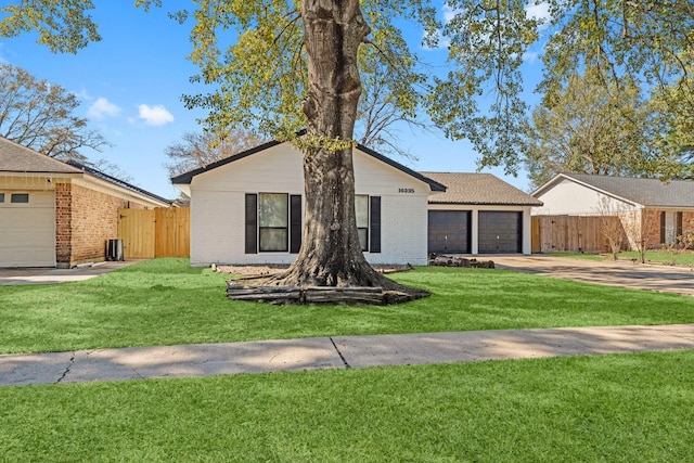 view of front of property featuring an attached garage, driveway, fence, and brick siding