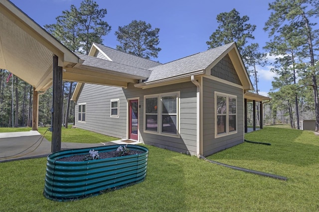 back of property featuring a yard and a shingled roof