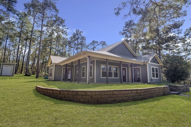 back of property featuring a yard and a shingled roof