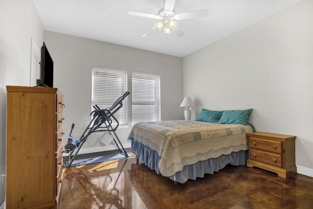 bedroom featuring finished concrete flooring, baseboards, and a ceiling fan