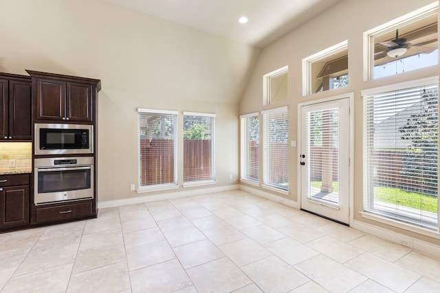 135 N Greatwood Glen Pl, Montgomery, TX 77316 - kitchen featuring stainless steel appliances, dark brown cabinets, high vaulted ceiling, light tile patterned floors, and baseboards