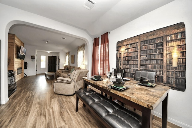 10330 Douglas Fir Villa Ave, Houston, TX 77044 - dining room featuring arched walkways, wood finished floors, a fireplace, and baseboards