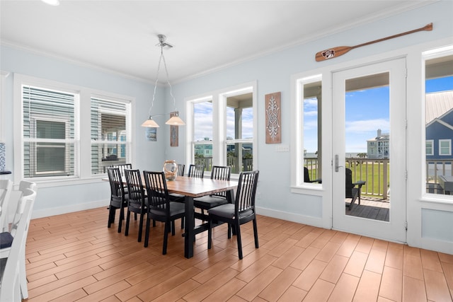 dining area featuring ornamental molding, baseboards, and light wood-style floors