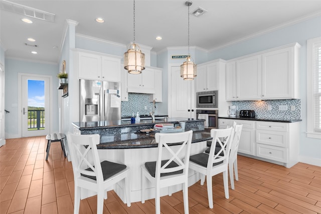 kitchen featuring stainless steel appliances, visible vents, and a breakfast bar