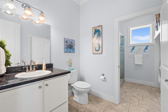 full bathroom featuring toilet, baseboards, a stall shower, and vanity