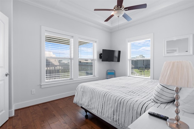 bedroom featuring a ceiling fan, ornamental molding, hardwood / wood-style floors, a raised ceiling, and baseboards