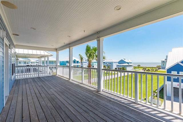 deck with a water view, a yard, and a residential view