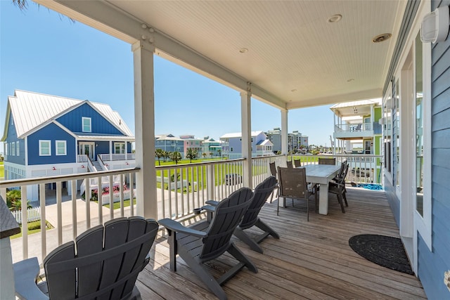 wooden terrace with outdoor dining area and a residential view