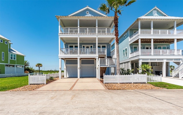 beach home with a garage, driveway, and fence