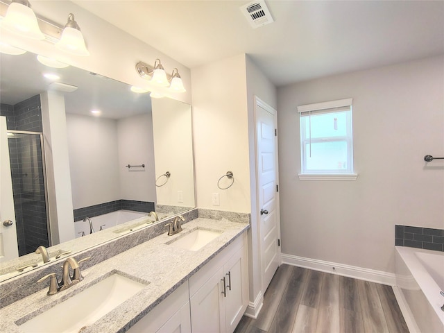 601 Greystone Ln, Angleton, TX 77515 - full bath with double vanity, wood finished floors, a bath, and a shower stall