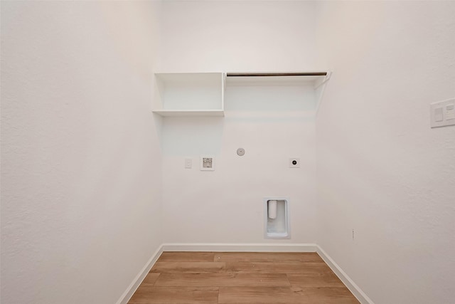 clothes washing area with laundry area, hookup for a washing machine, electric dryer hookup, hookup for a gas dryer, and light wood finished floors