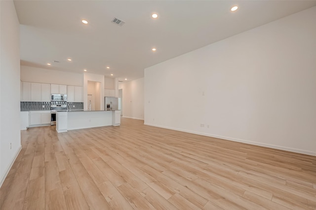unfurnished living room with visible vents, light wood-type flooring, and recessed lighting