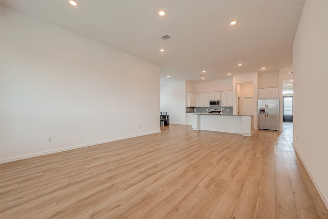 unfurnished living room with recessed lighting, visible vents, light wood-type flooring, and baseboards