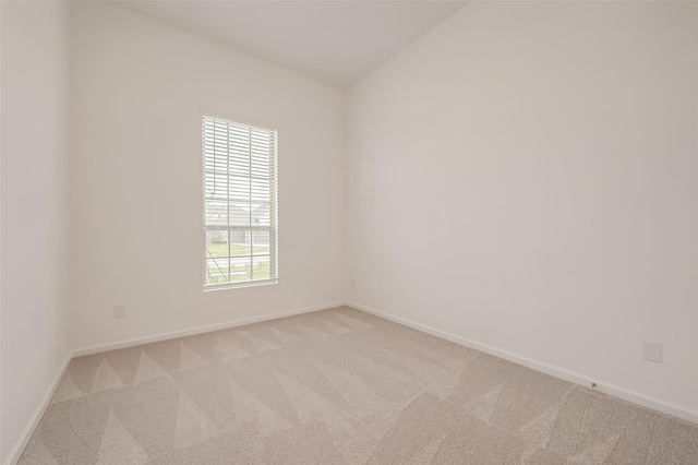 carpeted spare room featuring baseboards