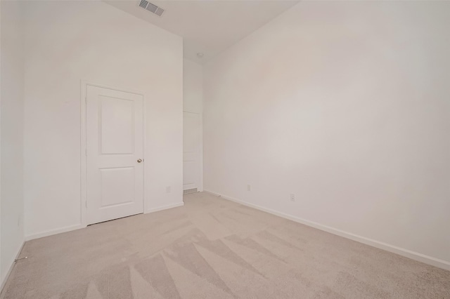 empty room with light carpet, visible vents, and baseboards